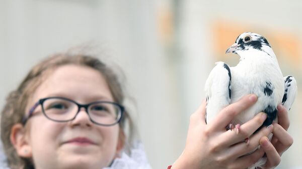 Девочка с  голубем после богослужения в праздник Благовещения Пресвятой Богородицы в Благовещенском соборе Московского Кремля