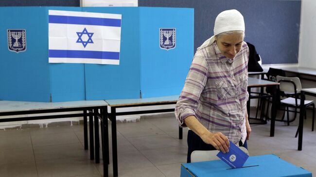 Женщина голосует на одном из избирательных участков в городе Тель-Авив в Израиле. 9 апреля 2019
