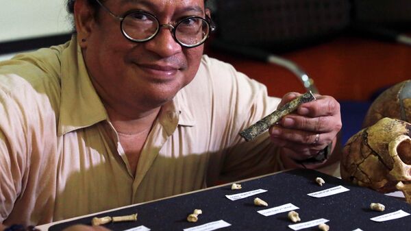 Филиппинский археолог Арманд Сальвадор Михарес демонстрирует кости, обнаруженные в пещере Кальяо на филиппинском острове Лусон