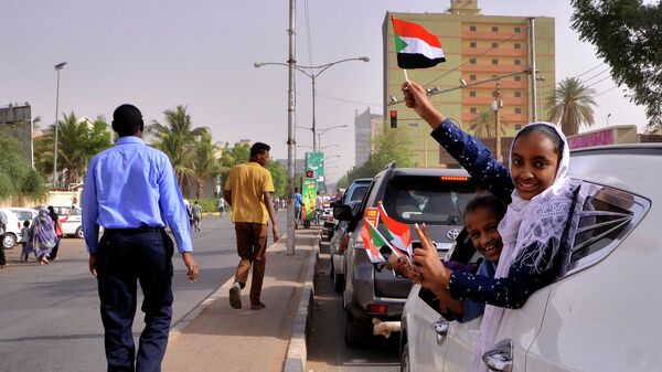 Люди с флагами Судана в Хартуме. 11 апреля 2019