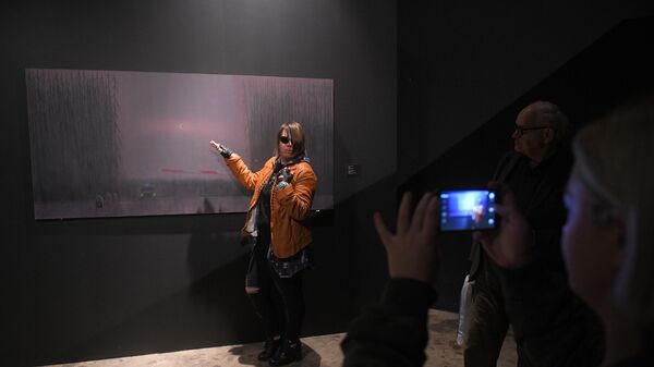 Девушка позирует на фоне картины Александра Якута на выставке Неон в Музее Москвы 