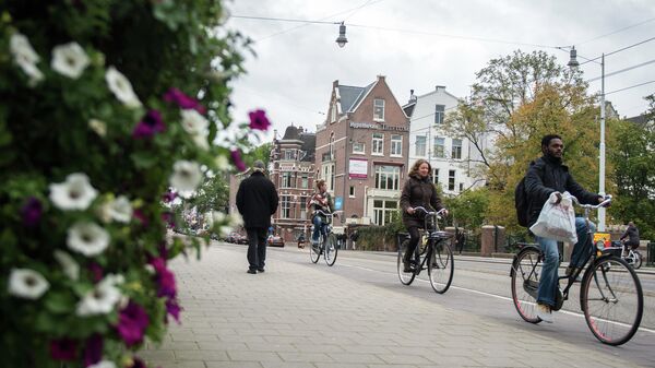 Горожане едут на велосипедах по одной из улиц в центре Амстердама