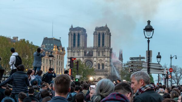 Люди неподалеку от собора Парижской Богоматери, где случился пожар
