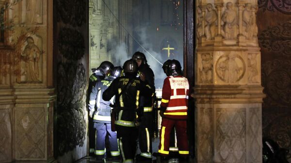 Пожарные у входа в собор Парижской Богоматери во время пожара