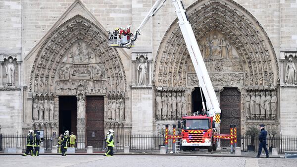 Пожарные возле собора Парижской Богоматери после пожара