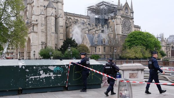 Сотрудники полиции огораживают территорию у собора Парижской Богоматери после пожара