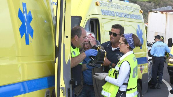 Медики оказывают помощь пострадавшему в результате ДТП с туристическим автобусом в Португалии. 17 апреля 2019