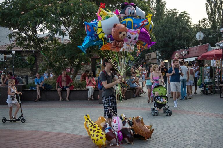 Отдыхающие на набережной Черного моря в Коктебеле