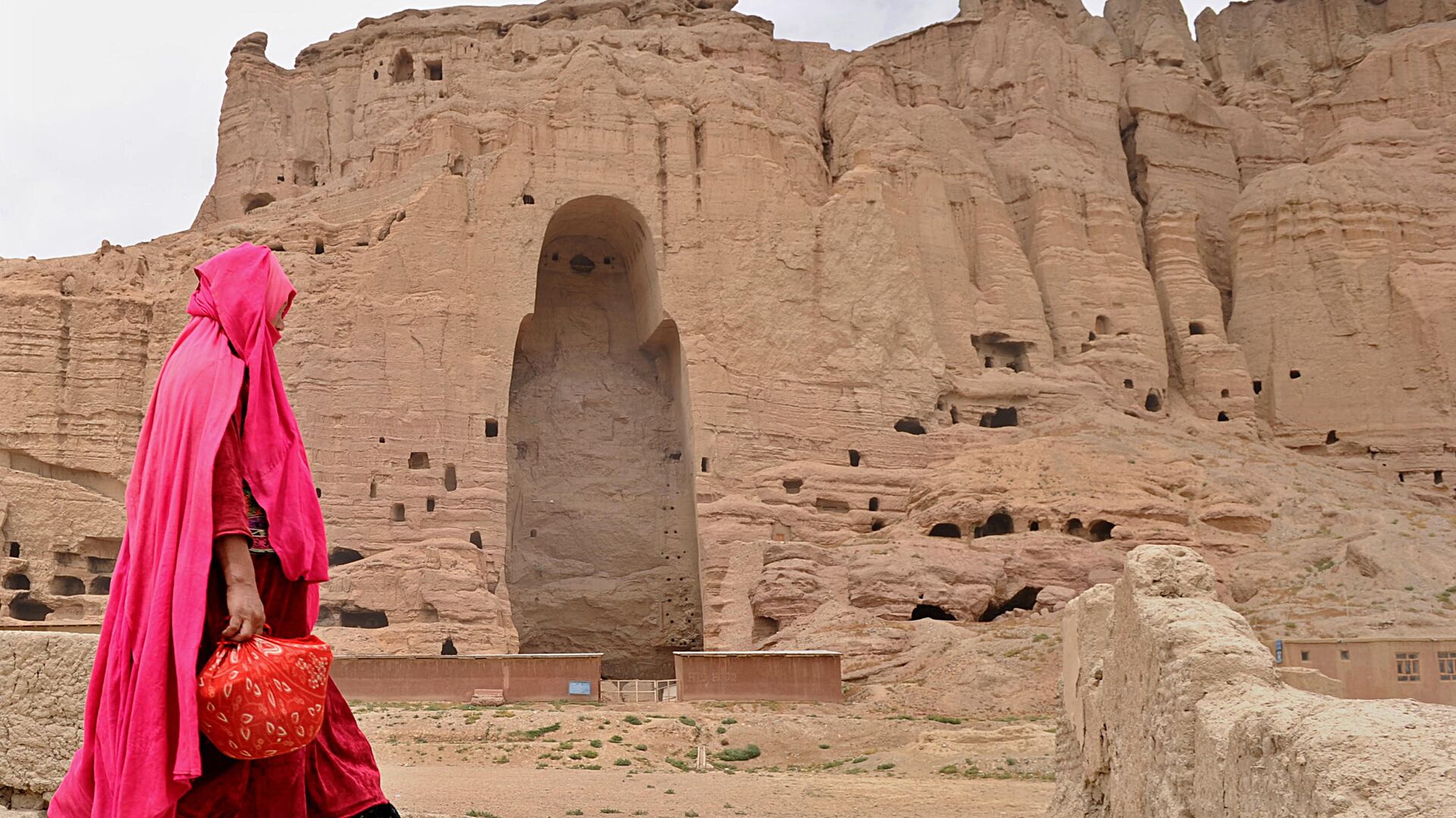 Женщина проходит мимо скал в Бамианской долине, где были высечены статуи. 2010 год - РИА Новости, 1920, 07.05.2019