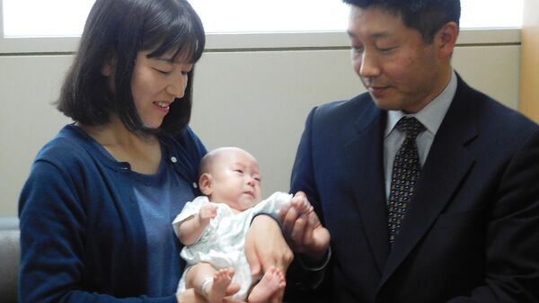 Родители с шестимесячным ребенком, родившимся в октябре прошлого года с весом 258 граммов, в детской больнице префектуры Нагано, Япония. 19 апреля 2019