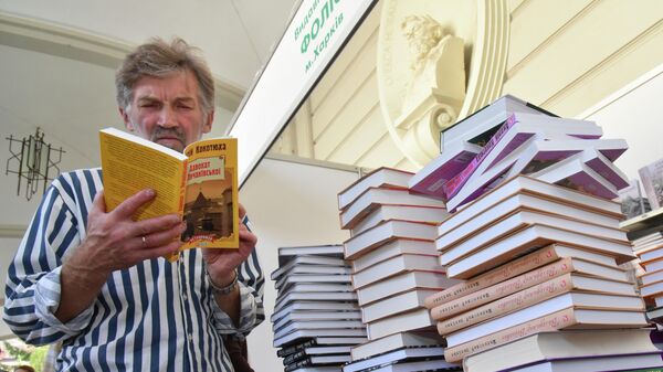 Посетитель читает книгу на книжной ярмарке во Львове