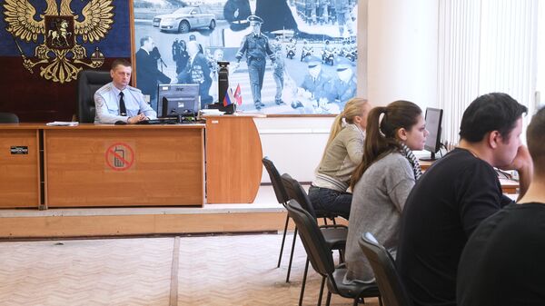 Люди сдают теоретические экзамены по правилам дорожного движения в отделении ГИБДД в Москве