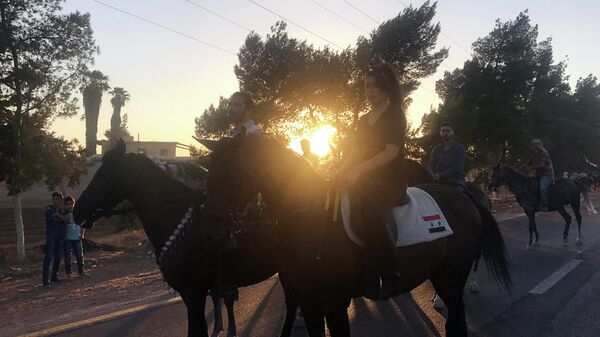 Сирийцы на лошадях едут в выставочный городок на южной окраине Дамаска
