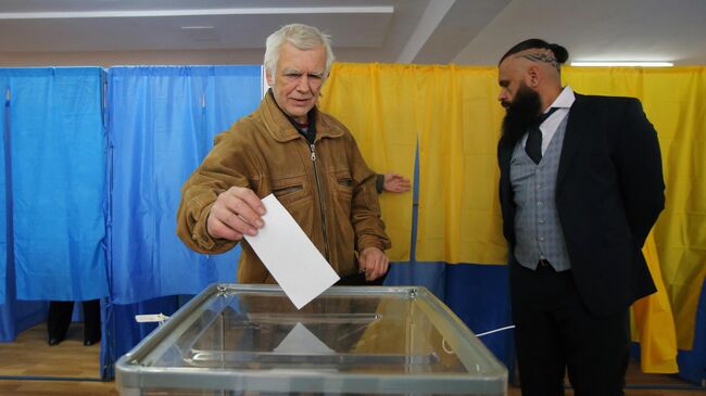Житель Киева во время голосования на одном из избирательных участков города в день второго тура выборов президента Украины
