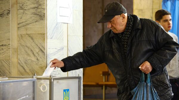 Мужчина во время голосования на одном из избирательных участков города Харькова в день второго тура выборов президента Украины