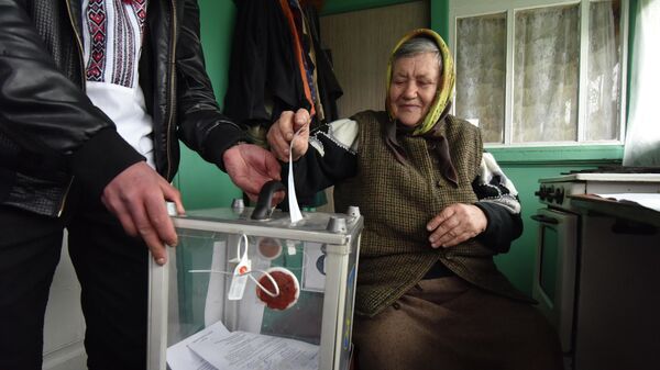 Женщина опускает бюллетень в мобильную урну для голосования во время второго тура президентских выборов на Украине