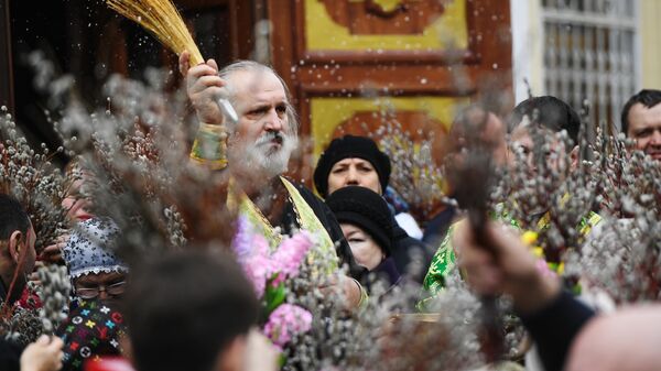 Священнослужитель и прихожане во время освящения вербы в Вознесенском кафедральном соборе в Новосибирске. 21 апреля 2019