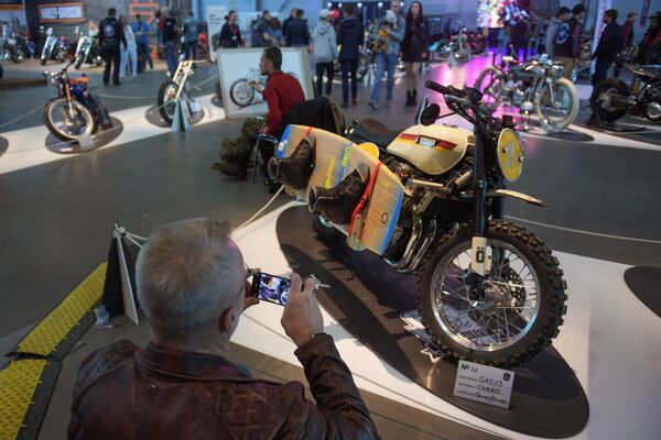 Посетитель фотографирует мотоцикл на Международном мотосалоне IMIS в Санкт-Петербурге