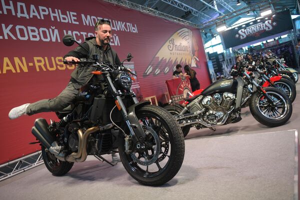 Посетитель на мотоцикле американской марки Indian на Международном мотосалоне IMIS в Санкт-Петербурге