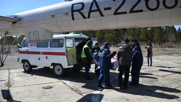 Транспортировка пострадавшего от пожара в селе Усть-Ималка в вертолет санитарной авиации для доставки в больницу Читы