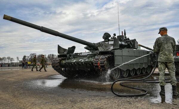 Военнослужащий моет танк Т-72, который примет участие в параде Победы на Красной площади 9 мая