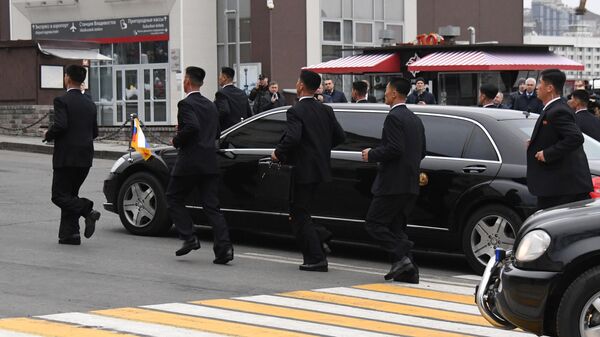 Сотрудники службы безопасности сопровождают автомобиль кортежа лидера КНДР Ким Чен Ына во Владивостоке
