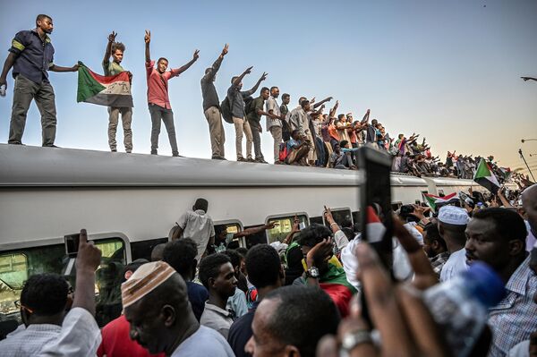 Суданские демонстранты из города Атбара на крыше поезда на железнодорожной станции Бахари в Хартуме