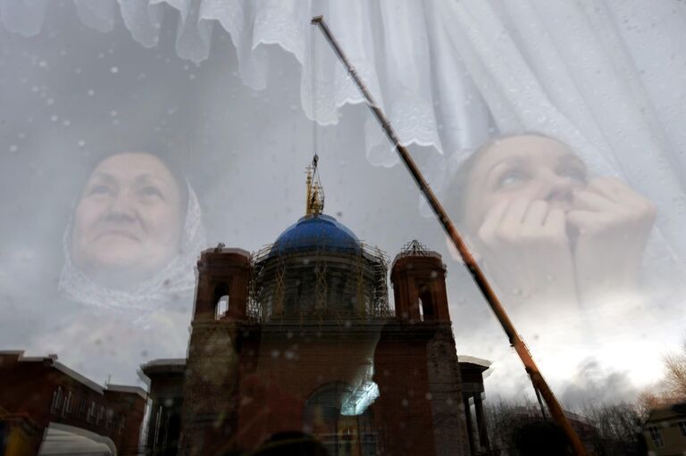 Верующие наблюдают за установкой крестов на купол Успенского собора в Екатеринбурге