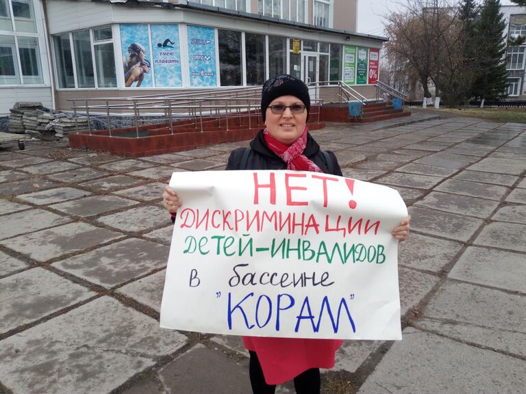 Владимирова с плакатом у здания бассейна