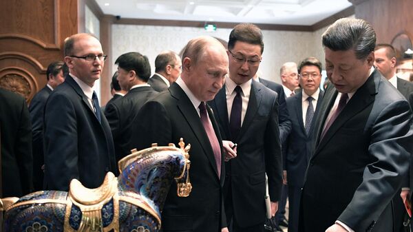 Президент РФ Владимир Путин и председатель КНР Си Цзиньпин обмениваются подарками после рабочего завтрака