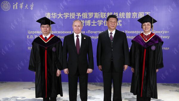 Президент РФ Владимир Путин и председатель Китайской народной республики (КНР) Си Цзиньпин (второй справ) на церемонии вручения диплома почетного доктора Университета Цинхуа в Пекине