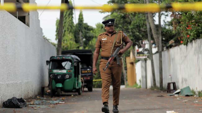Шри-ланкийский полицейский около отеля на окраине Коломбо, где произошел взрыв. 26 апреля 2019