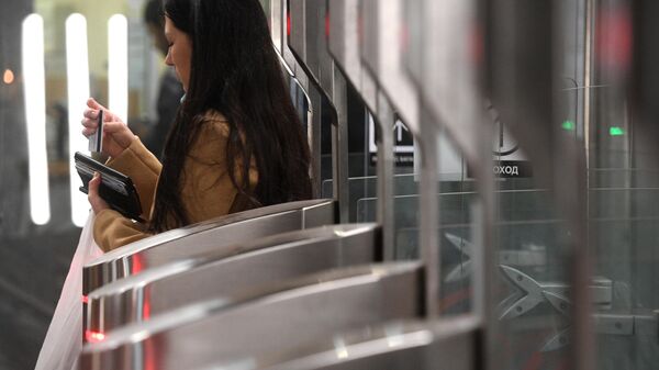Пассажир московского метро проходит через турникеты на станции Октябрьское Поле