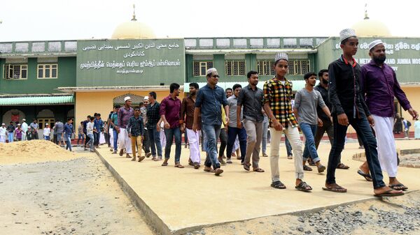 Мусульмане выходят из мечети после молитвы в Каттанкуди, Шри-Ланка