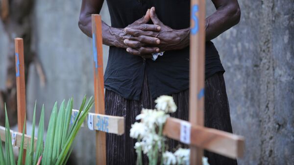 Женщина скорбит рядом с могилой родственника, погибшего во время взрывов в в Негомбо, Шри-Ланка