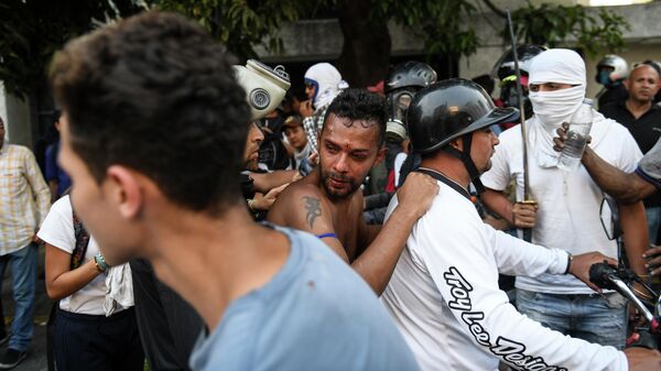 Одного из протестующих, раненного во время столкновения с Национальной гвардией Венесуэлы в Альтамире, районе Каракаса, увозят на мотоцикле