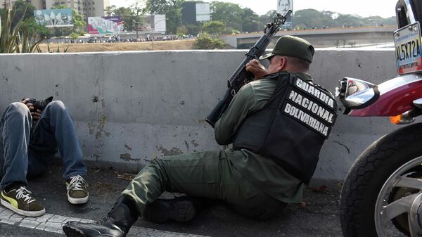 Сотрудник Национальной гвардии Венесуэлы, поддерживающий оппозиционного лидера Хуана Гуаидо, на шоссе Франсиско Фахардо