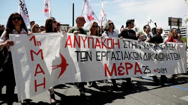 Участники первомайской демонстрации в Афинах, протестующие против экономической политики правительства и выступающие за реализацию прав трудящихся на достойную зарплату и социальную защиту