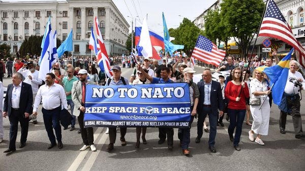 Представители США, Швеции, Великобритании, Израиля и Непала несут транспарант с надписью Нет НАТО во время первомайского шествия в Симферополе