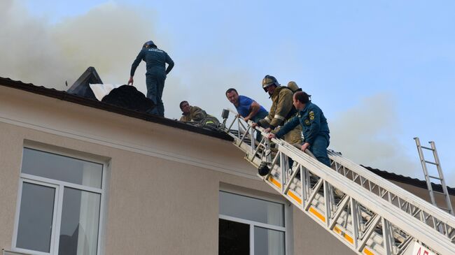 Сотрудники пожарной службы на крыше здания русской средней школы №2 имени А.С. Пушкина в Сухуме, где произошло возгорание. 2 мая 2019