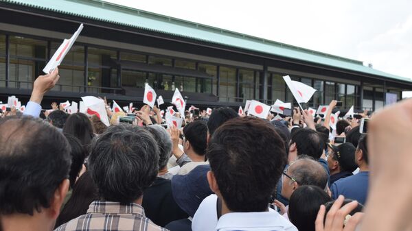 Люди приветствуют нового императора Нарухито возле императорского дворца в Токио