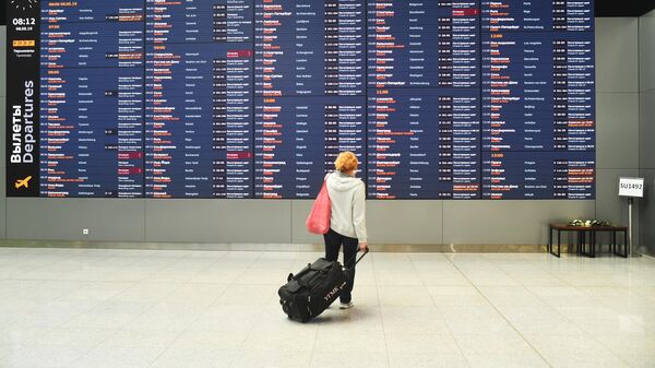Женщина возле информационного табло с расписанием рейсов в аэропорту Шереметьево