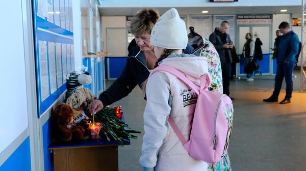Пассажиры зажигают свечу  в аэропорту Мурманска в знак траура по жертвам катастрофы самолета Аэрофлота