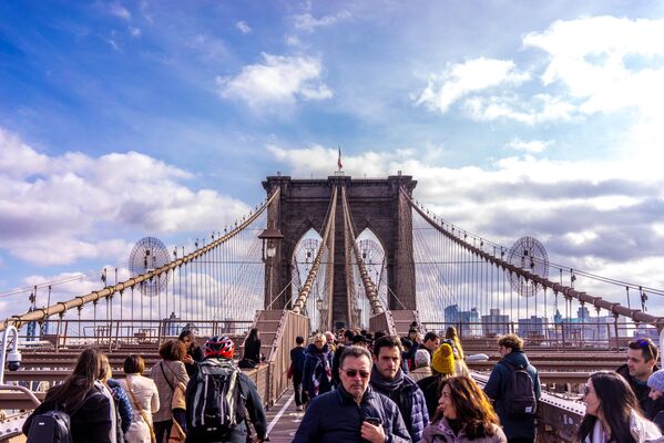 Прохожие на Бруклинском мосту в Нью-Йорке