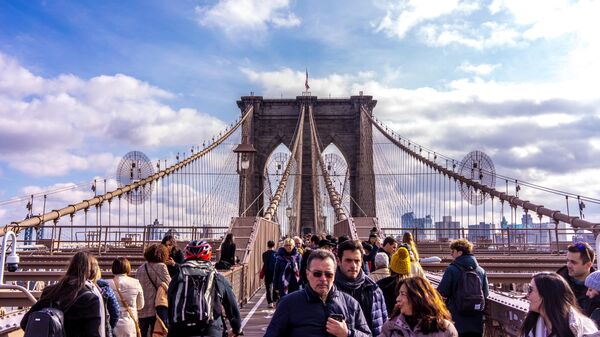 Прохожие на Бруклинском мосту в Нью-Йорке