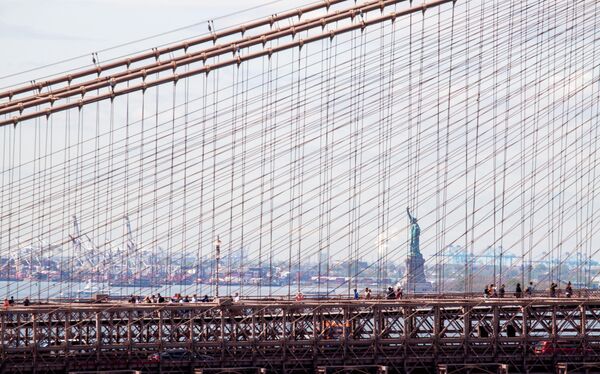 Вид на Стасую Свободы сквозь Бруклинский мост в Нью-Йорке