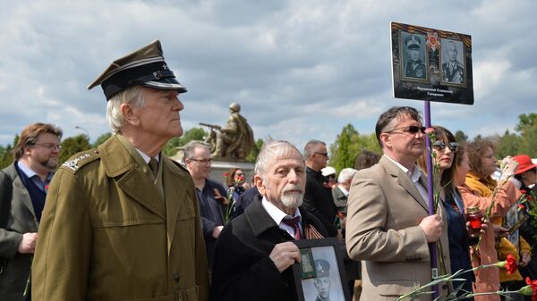 Участники акции Бессмертный полк на военно-мемориальном кладбище в Варшаве. 7 мая 2019