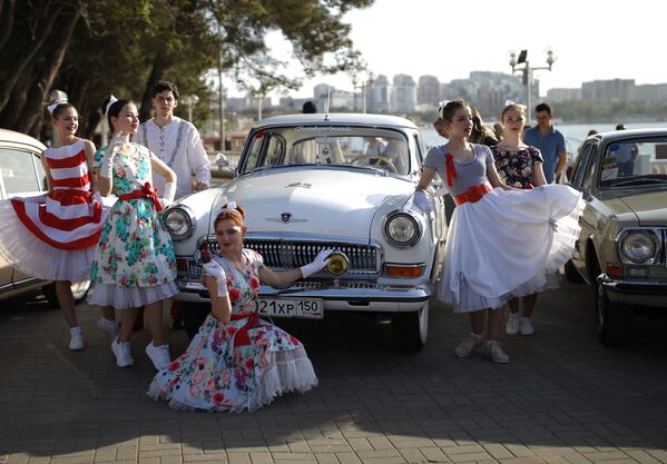 Девушки фотографируются возле автомобиля ГАЗ-21 Волга в Геленджике