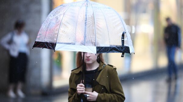 Девушка во время дождя на одной из улиц в Москве
