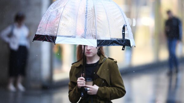 Девушка во время дождя на одной из улиц в Москве
